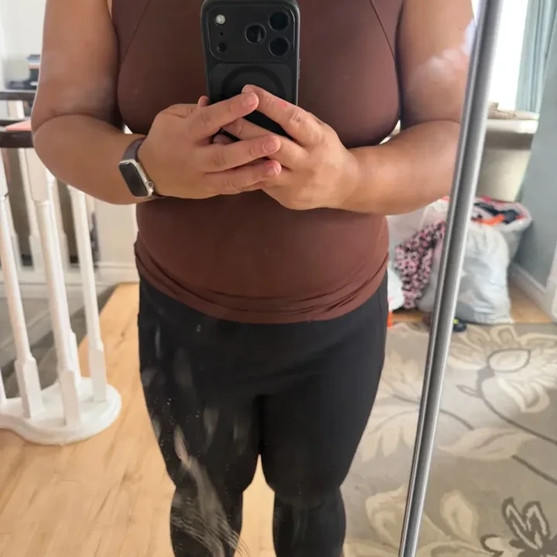Customer review mirror photo wearing a coffee tank top with black trousers
