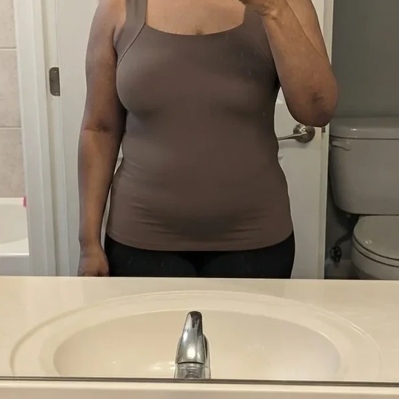 Theresa wearing a coffee-colored tank top in a customer mirror photo